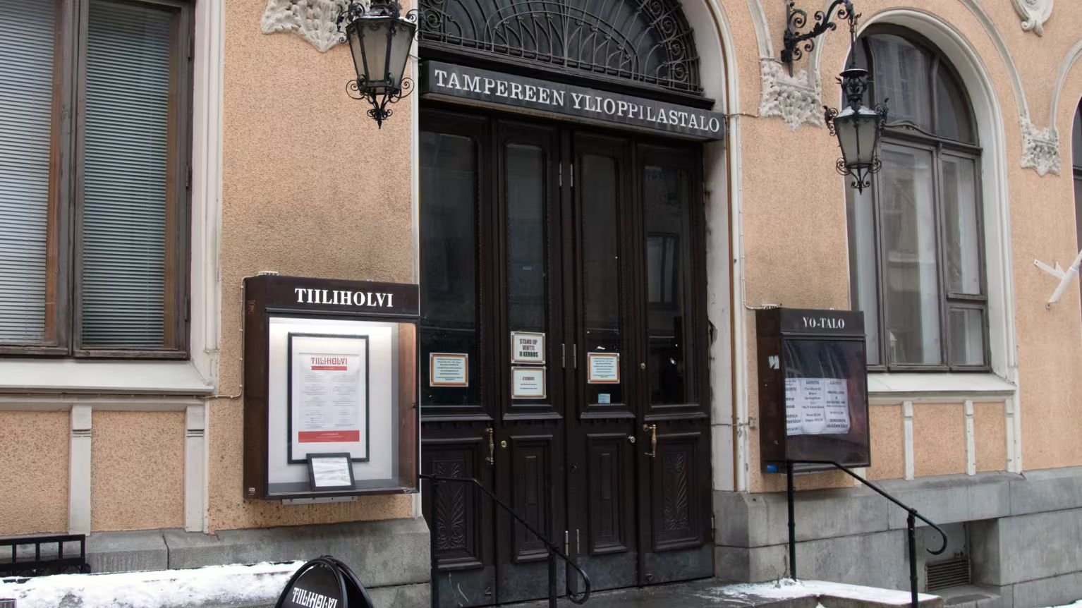 Tampereen Ylioppilastalon pääovet Kauppakadulla, ovien vieressä Tiiliholvin ja YO-Talon ilmoitustaulut